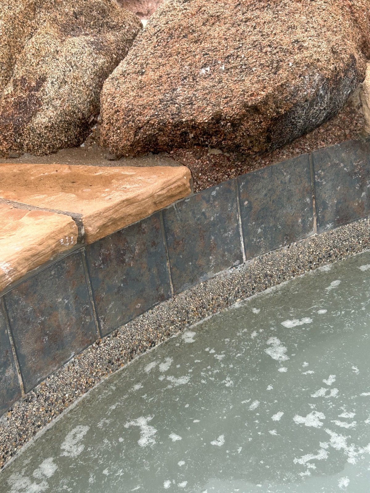 After professional tile cleaning at the same Gilbert pool showing darker waterline tile with much of the white buildup removed